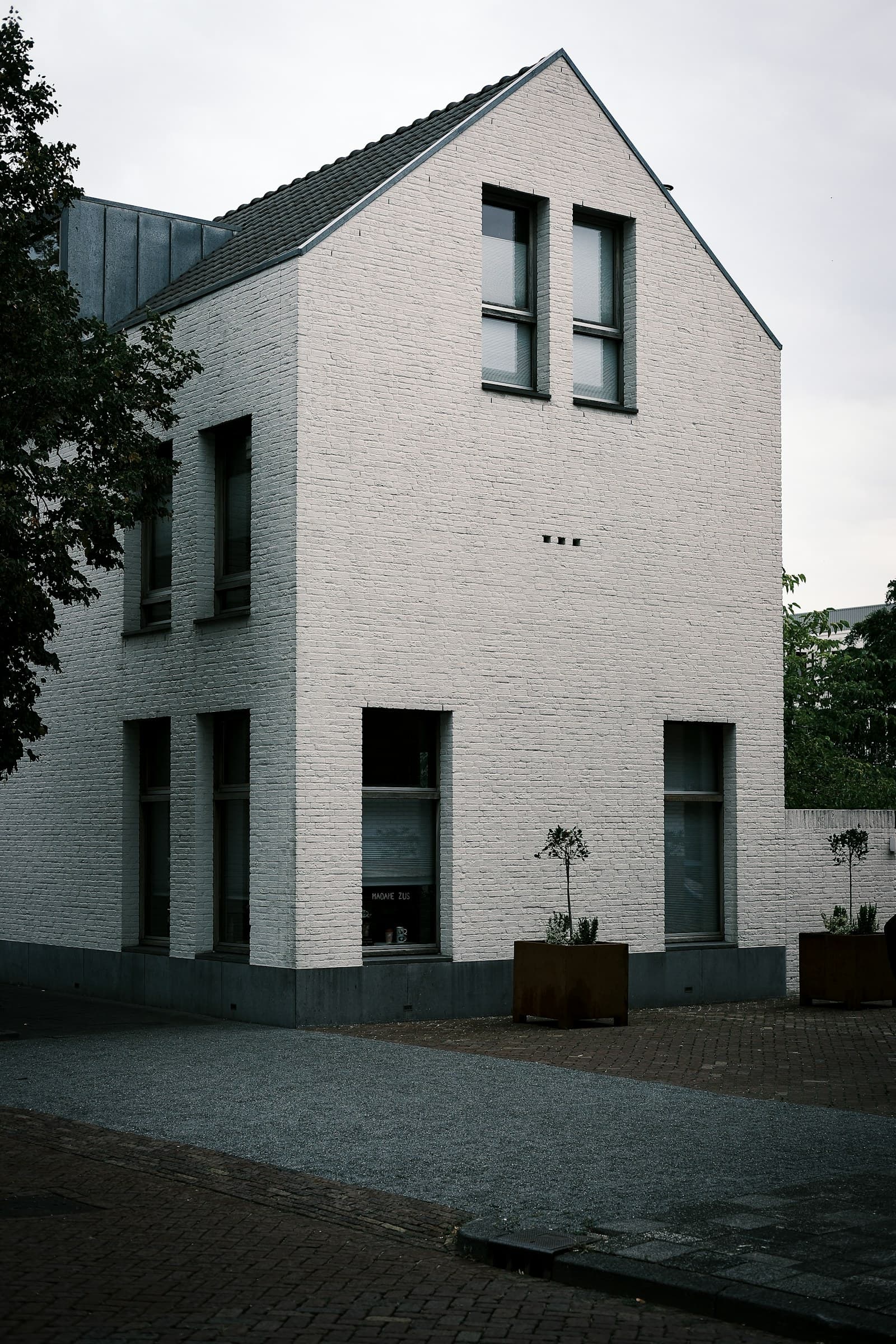 Maison en briques peintes en blanc, toit en pente