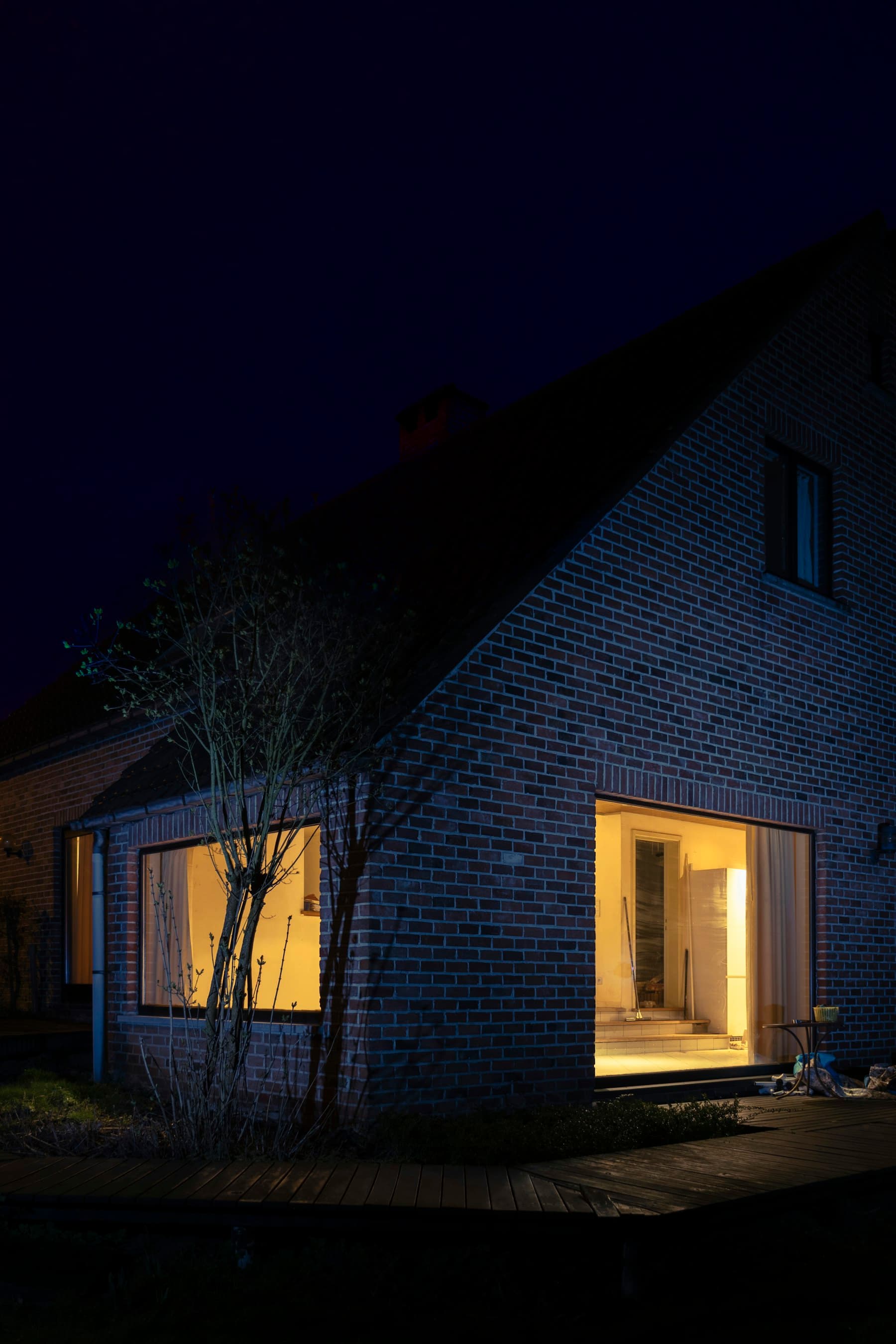 Maison en briques le soir, fenêtres éclairées